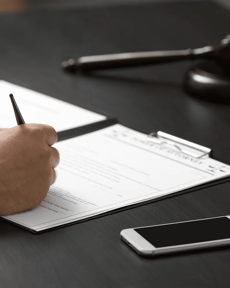 Client signing a bail bond agreement at Sloan Bail Bonding in Charlotte